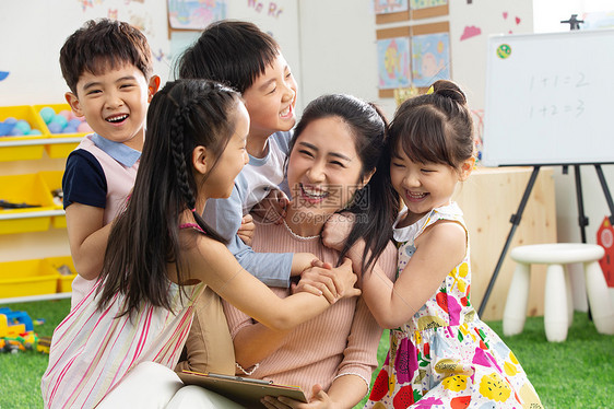 早期教育青年女人幼儿园老师和小朋友们拥抱在一起图片