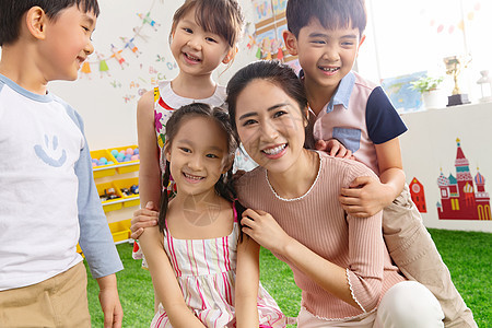 休闲装协助男孩幼儿园老师和小朋友们拥抱在一起图片