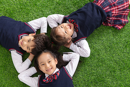 摄影头摄影亚洲智力小学生们躺在草地上背景
