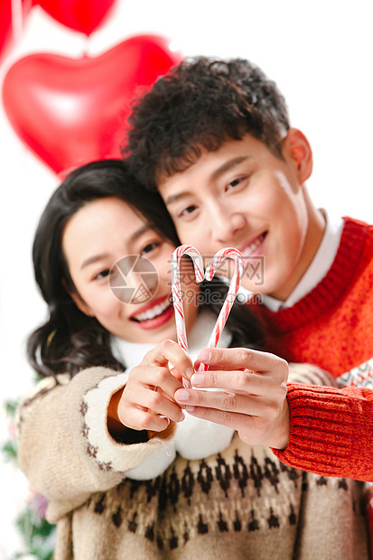 圣诞信心爱心快乐的青年情侣拿着拐杖糖图片