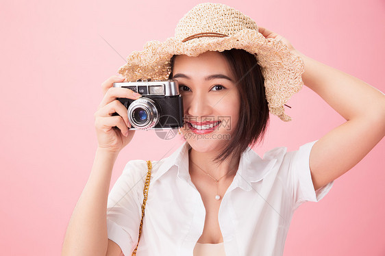 影棚拍摄粉色背景健康的青年女人旅行图片