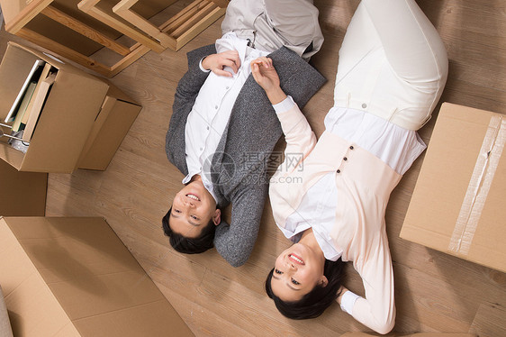 盒子装修高视角年轻夫妇躺在地板上图片