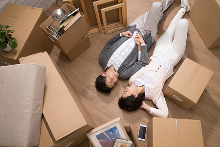 包装躺着起居室年轻夫妇躺在地板上图片