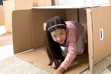 创造力儿童嬉戏的小女孩藏在纸箱里图片