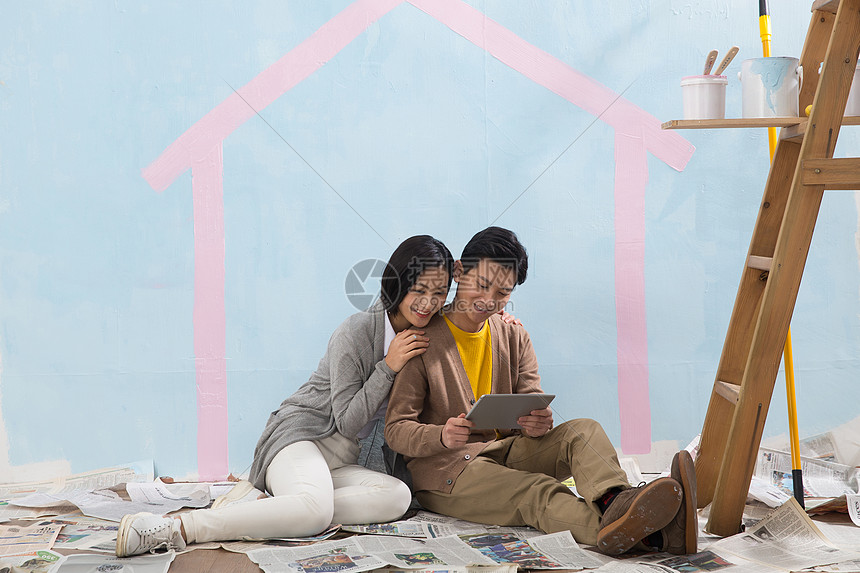 倚靠亚洲人欢乐年轻夫妇装修房子图片