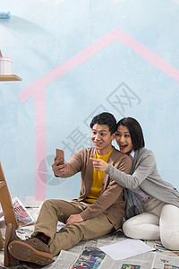 家务劳动无线电技术挨着年轻夫妇用手机拍照图片