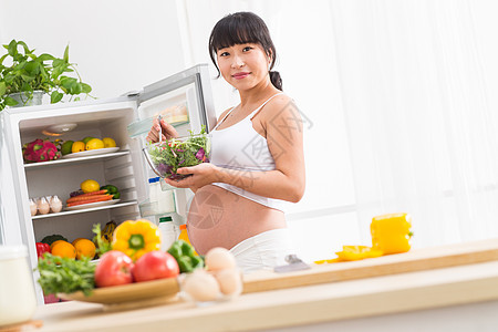 孕妇打开冰箱拿蔬菜图片