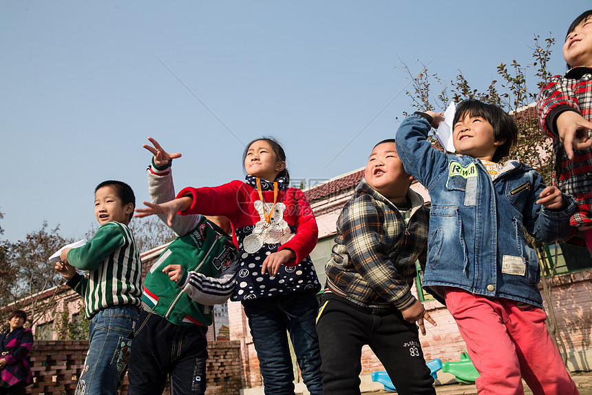 微笑的相伴活力乡村小学生在学校放纸飞机