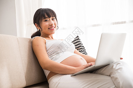 期待怀孕骄傲孕妇使用电脑图片