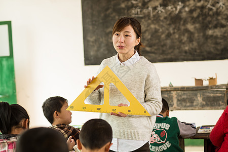 老师指导教师女生乡村女教师和小学生在教室里图片