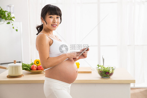 户内东亚仅女人孕妇看平板电脑图片
