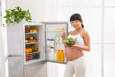 健康生活方式仅一个人温馨孕妇打开冰箱拿蔬菜图片