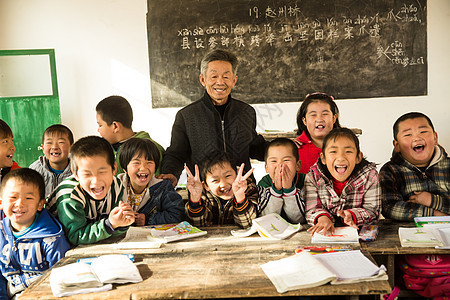 微笑的责任可爱的乡村男教师和小学生在教室里图片