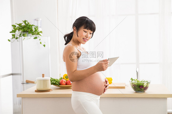 温馨餐饮休闲装孕妇看平板电脑图片