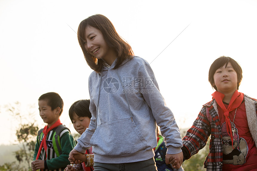 逆境手牵手五个人乡村女教师和学生在户外图片