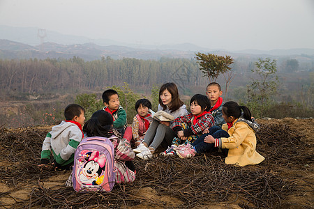 人男孩相伴乡村教师和小学生在户外学习图片