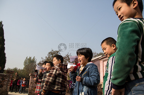 可爱的幸福表现积极乡村小学生在学校放纸飞机图片