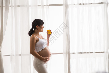 站着轻松摄影孕妇喝果汁图片