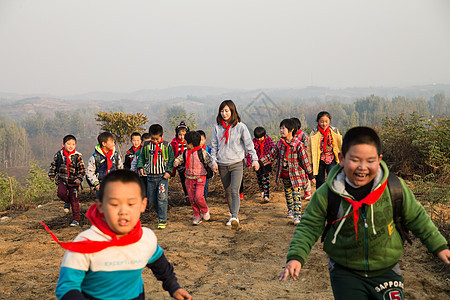 红领巾微笑的成年人乡村女教师和学生在玩耍图片