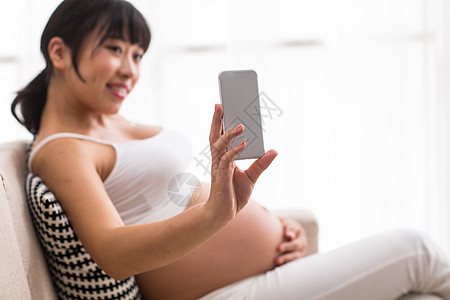 孕育露出肚子孕妇用手机自拍图片