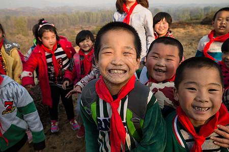 红领巾飘起来女生希望东方人乡村女教师和学生在玩耍背景