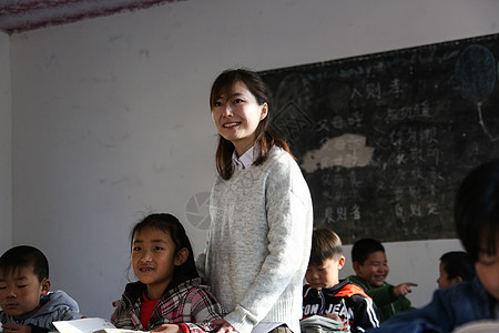 友谊亚洲人微笑的乡村女教师和小学生在教室里图片
