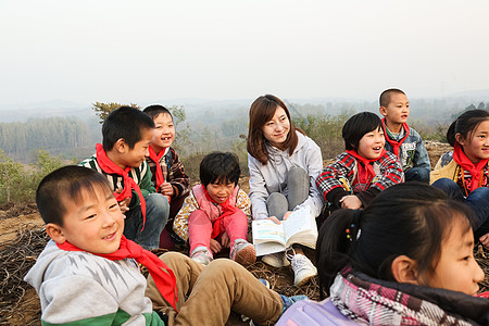 小孩阅读东亚人责任乡村教师和小学生在户外学习背景