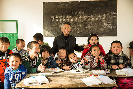 逆境团结热情乡村男教师和小学生在教室里图片