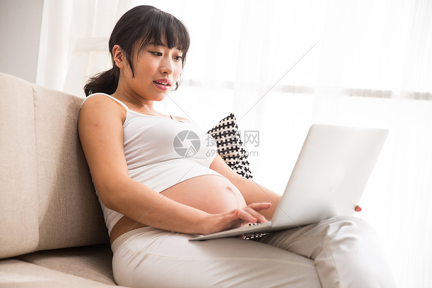 关爱孕育腹部孕妇使用电脑图片