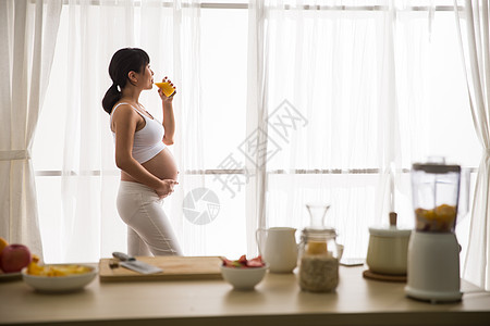 孕妇喝橙汁20多岁露出肚子杯子孕妇喝果汁背景