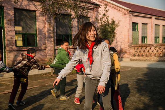 乐观团队户外乡村教师和小学生在学校里做游戏图片