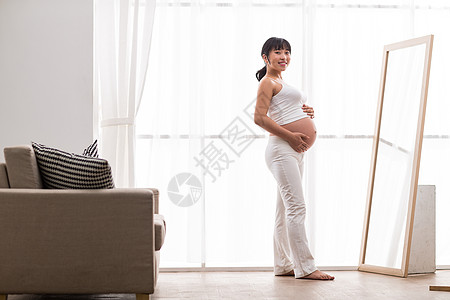 起居室腹部幸福孕妇照镜子图片