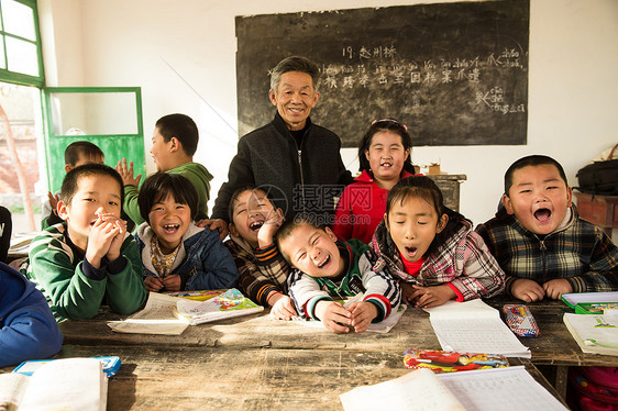 成年人农村艰苦乡村男教师和小学生在教室里图片