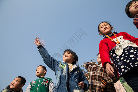 平房户外乡村小学生在学校放纸飞机图片