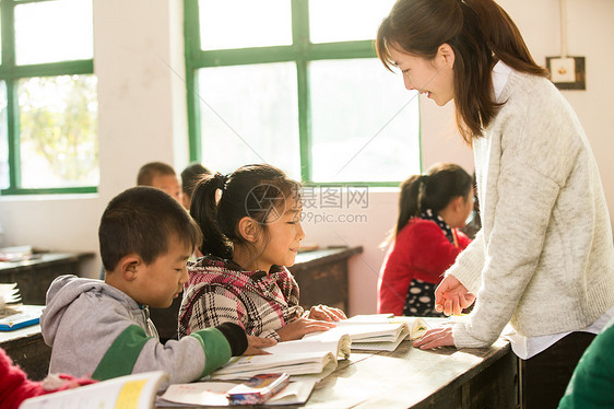 可爱的志愿者少量人群乡村女教师和小学生在教室里图片