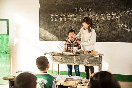 关爱东方人责任乡村女教师和小学生在教室里高清图片