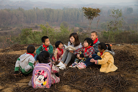 指导女生援助乡村教师和小学生在户外学习图片