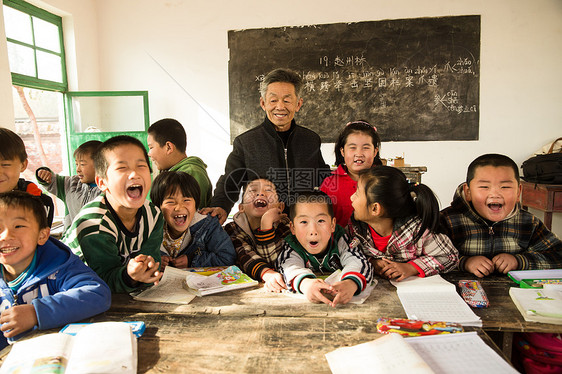 相伴乐观愉悦乡村男教师和小学生在教室里图片