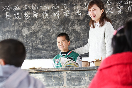 青年人白昼课桌乡村女教师和小学生在教室里图片