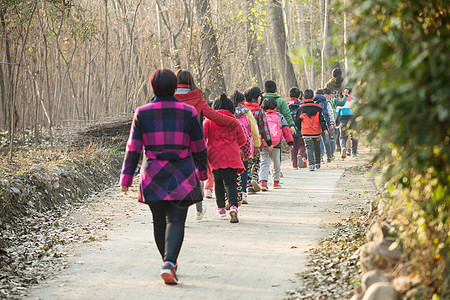 队列团结东方人乡村女教师和学生户外活动高清图片