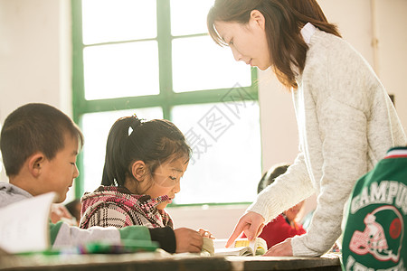 女教师和学生农村少量人群桌子乡村女教师和小学生在教室里背景