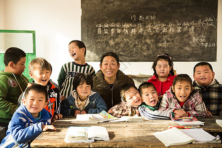 桌子成年人休息乡村女教师和小学生在教室里图片