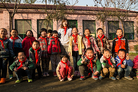 学龄儿童人微笑的乡村教师和小学生在学校里图片