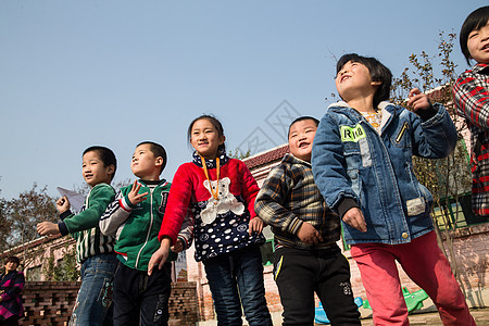 关爱可爱的亚洲人乡村小学生在学校放纸飞机图片
