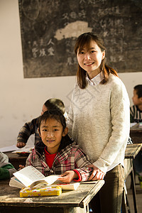 志愿者努力指导教师乡村女教师和小学生在教室里图片