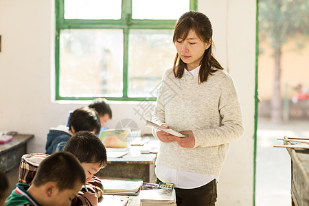 8岁到9岁东亚水平构图乡村女教师和小学生在教室里高清图片