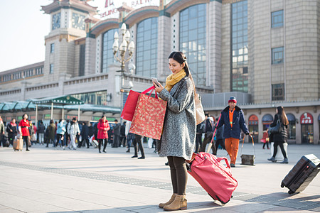 美女围巾休闲装日光旅行者青年女人在站前广场背景