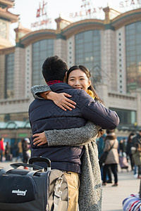 车站回家中年男人旅行箱亲密青年情侣在火车站背景