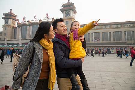 旅途拉杆箱过年幸福家庭在站前广场图片