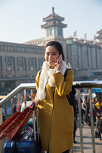 春运东方人拿着青年女人在站前广场图片